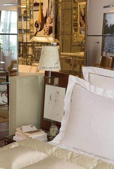 A bedroom with a bed and a mirror at Raffles Paris, where a French masterpiece gets unveiled.