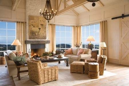 A living room with large windows and wicker furniture in The Farm at Cape Kidnappers.
