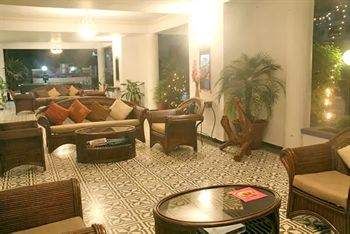 A lobby with wicker furniture and a fireplace, depicting Portuguese heritage and tradition.