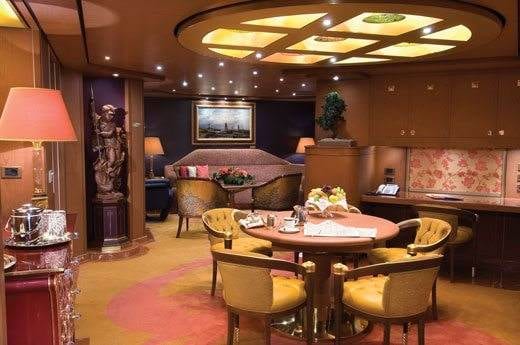 Experience the opulent luxury of a living room in the penthouse suite while cruising on Holland America Line.