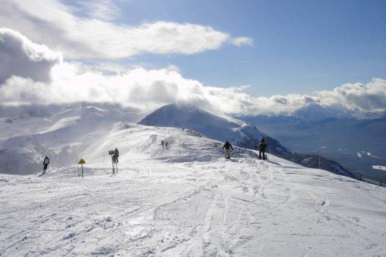 A group of people skiing on a snow covered mountain at a family-friendly ski resort in the Canadian Rockies.