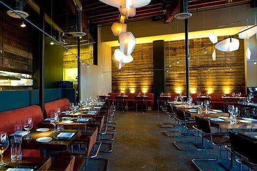 The interior of a restaurant with wooden tables and chairs, inviting you to pamper your taste buds with Akasha.