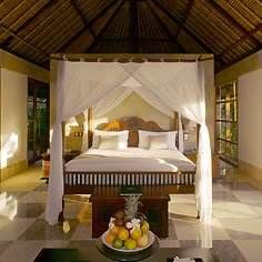 Explore a peaceful isle with a four poster bed and a coffee table.