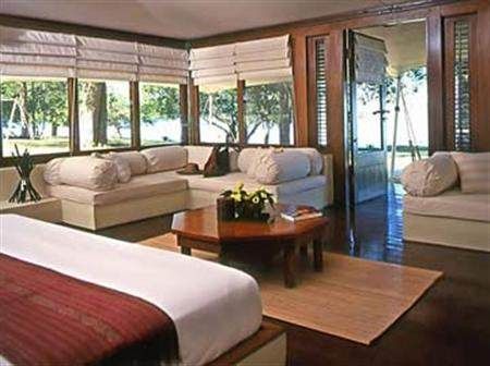 A room with a bed, couches, and a traditional Balinese experience.