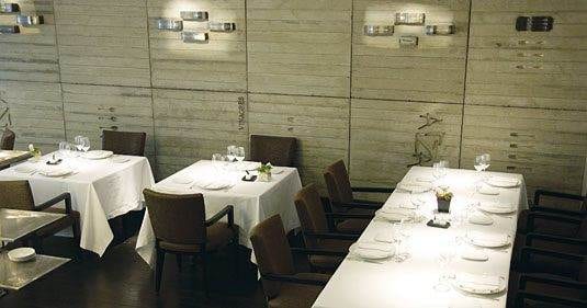 A dining room with white tables and chairs featuring excellent Basque cuisine at Arzak.