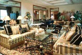 A living room with gold furniture and a piano in the Atlantis Bridge Suite.