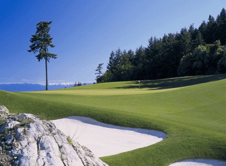 A golf course with sand bunkers and trees at Canada's Beautiful Pacific Coast Resort.