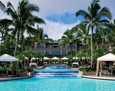 A pool surrounded by palm trees and umbrellas at the Ritz-Carlton, Kapalua's $180 Million Makeover in Maui.