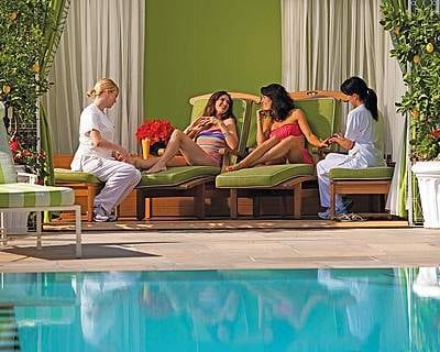 A group of Glam-Girls relaxing around a pool on their Beverly Hills getaway.
