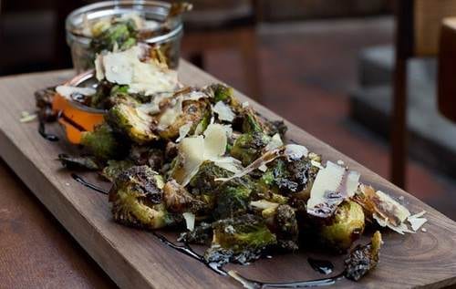 Chef Devon Junkin serves Brussels sprouts on a wooden tray with a jar at BO-beau kitchen + bar in Ocean Beach, CA.