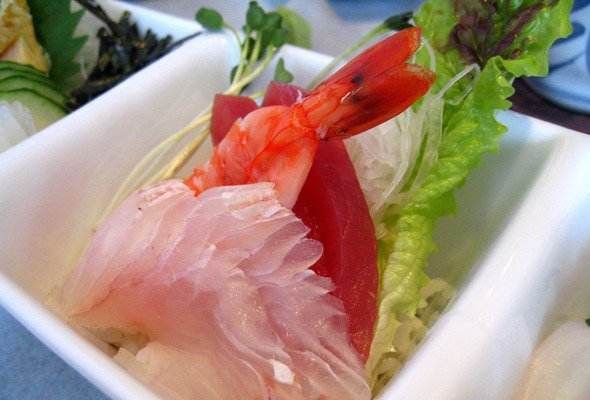 Japanese food with shrimp and vegetables served in a white bowl.