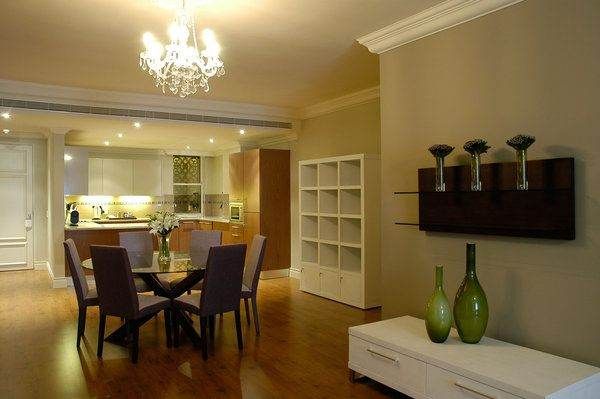 A dining room with a chandelier and wooden floors at Cape Royale – Pride of Cape Town.