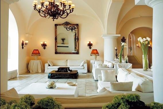 A living room with white furniture and a chandelier at the Capri Palace Hotel & Spa.