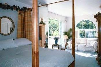 A+ for B & B::Ashland Creek Inn offers a luxurious bedroom with a four poster bed and a window overlooking the beautiful scenery.