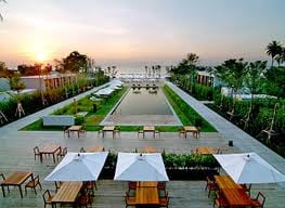 A Thailand resort with tables and chairs at sunset.