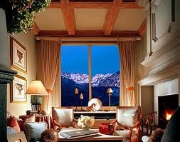 A luxurious living room with a fireplace and stunning mountain views.