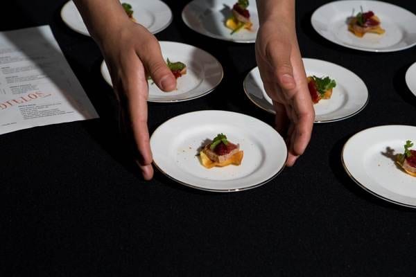 A person is holding plates of food at a stellar event on Treasure Island.