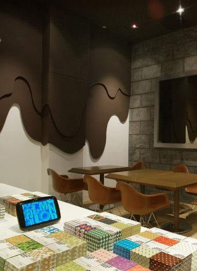 A coffee shop with a lot of books and a clock, raising the chocolate bar.