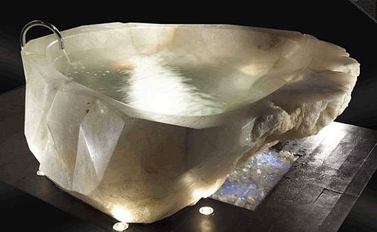 An extravagant crystal bathtub carved from a large piece of rock.