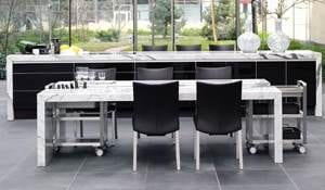 A black and white kitchen with a designer dining desk.