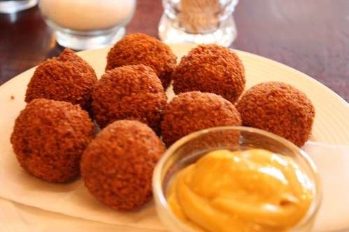 A plate of meatballs with artistic mustard on it.