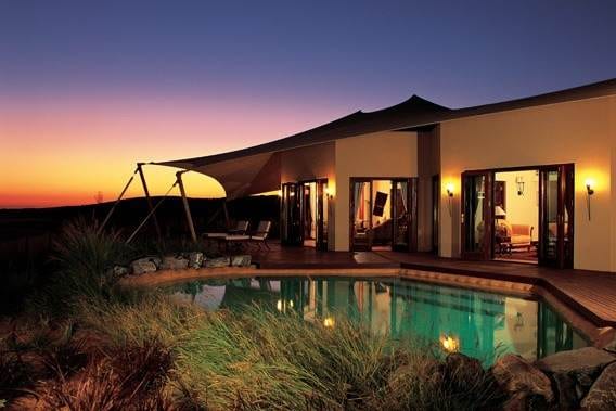 Relax in a tranquil oasis: The Al Maha Desert Resort & Spa offers a tent with a pool at dusk.