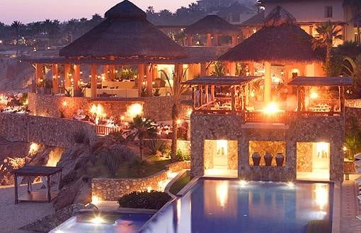 A tropical heaven resort on the edge of a cliff at dusk.
