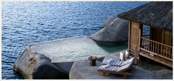 A luxurious house with a pool located on the edge of the ocean at The Proverbial Ecstasy resort.