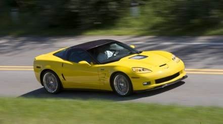 A yellow corvette driving on the road.