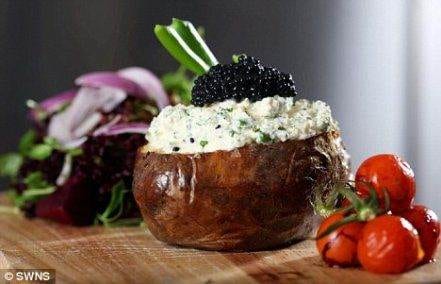 Grab the World's Costliest Baked Potato with black caviar and tomatoes on a cutting board.