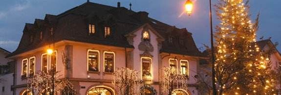 A building with a lit-up Christmas tree.