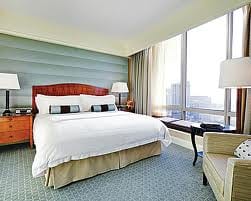 A luxury hotel room with a large bed and a view of the city in San Francisco.