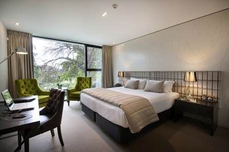 Step into the wonderland of The George Christchurch, By the River Avon, with a large bed and a desk.