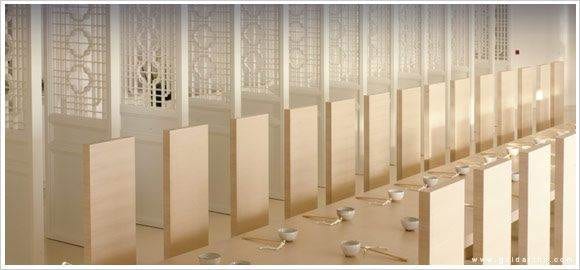 A row of wooden benches in a room, inspired by Hong Kong’s flavor.