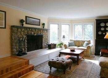 A resort home with hardwood floors and a stone fireplace on the Vermont mountainside.