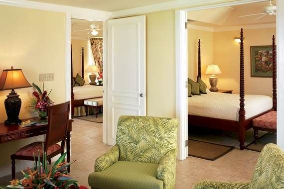 Explore the Caribbean paradise from a room with a bed, chairs, and a desk at Half Moon Rock Resort.