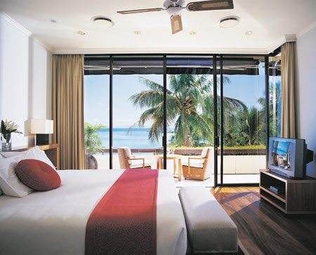 A bed or beds in a room at the Hayman Island Resort, offering a beach lifestyle in the midst of the Coral Sea.