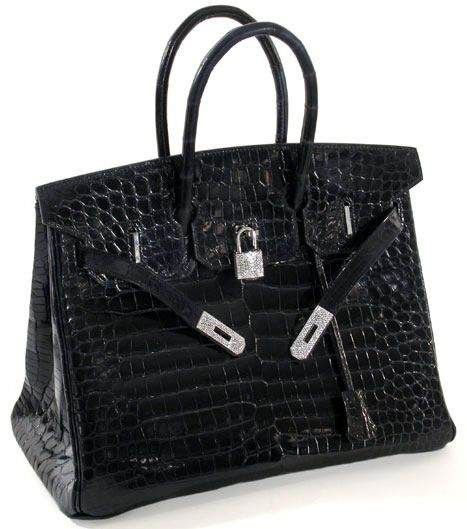 A black crocodile skin handbag with diamonds on a white background.