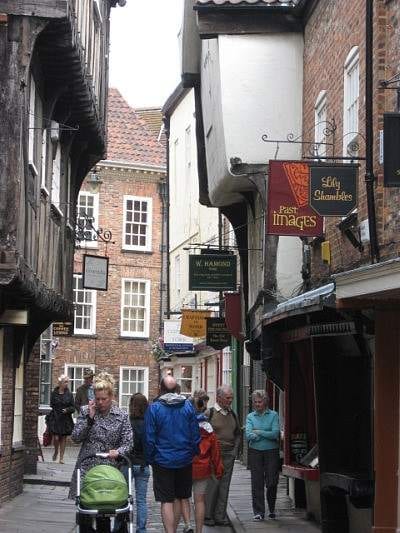 Young woman walking down a narrow street in York, England.