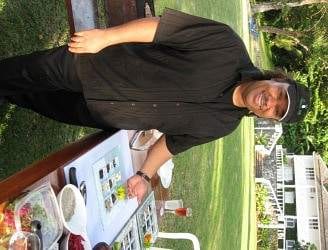 A man standing in front of a table with food on it at Montego Bay.