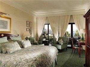 Royalty of traditional Arab in the Presidential Suite of Al Bustan Palace, where a large bed and green carpet await.