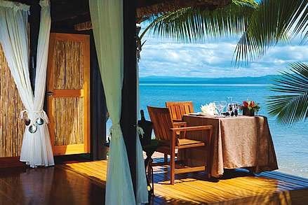 Romantic ocean views from a room with a table and chairs at Jean-Michel Cousteau Fiji.