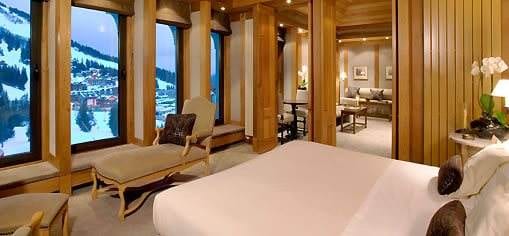 A room with a bed and a ski chaise lounge.
