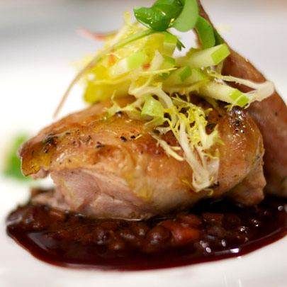 A dish of chicken with black beans on a white plate inspired by the flavor of France at Les Nomades.
