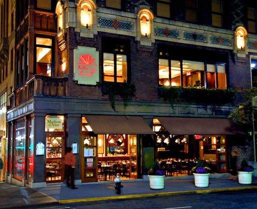 The Library Hotel - NYC: A restaurant at night on a city street corner.