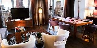 Hotel Eventi comes alive with a living room featuring large windows and a TV.