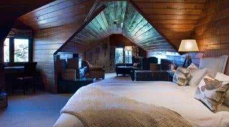 A rustic log cabin retreat with a cozy bed.