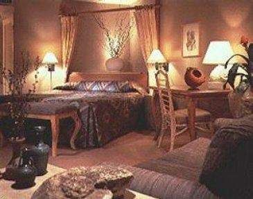 A desert-themed bedroom with a bed, couch and lamps.