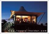 Latitude 131: A luxury tent at night with stairs leading up to it.