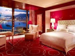 A luxurious red bedroom with a view of the city in the Grand Salon Suite.